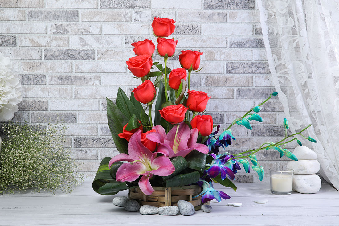 Buy 12 Orange Roses, 1 Pink Lilies, and 2 Blue Orchids in a Basket