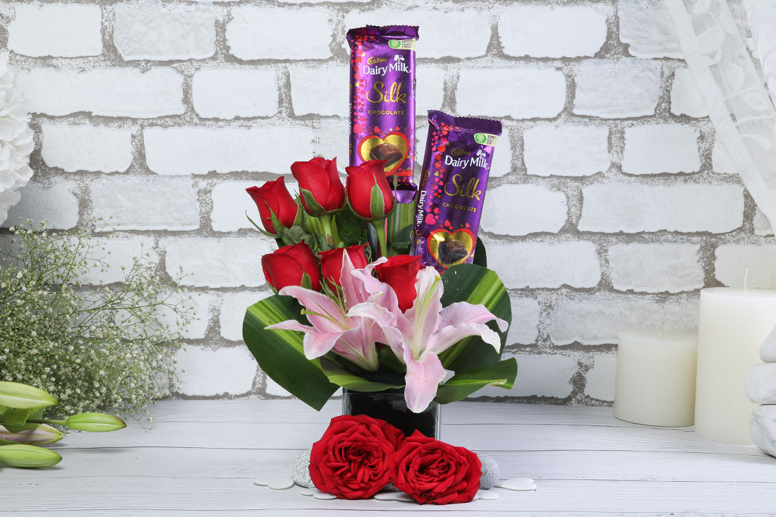 6 Red Roses, 2 Dairy Milk Silk, and 1 Astatic Pink Lilies in a Basket