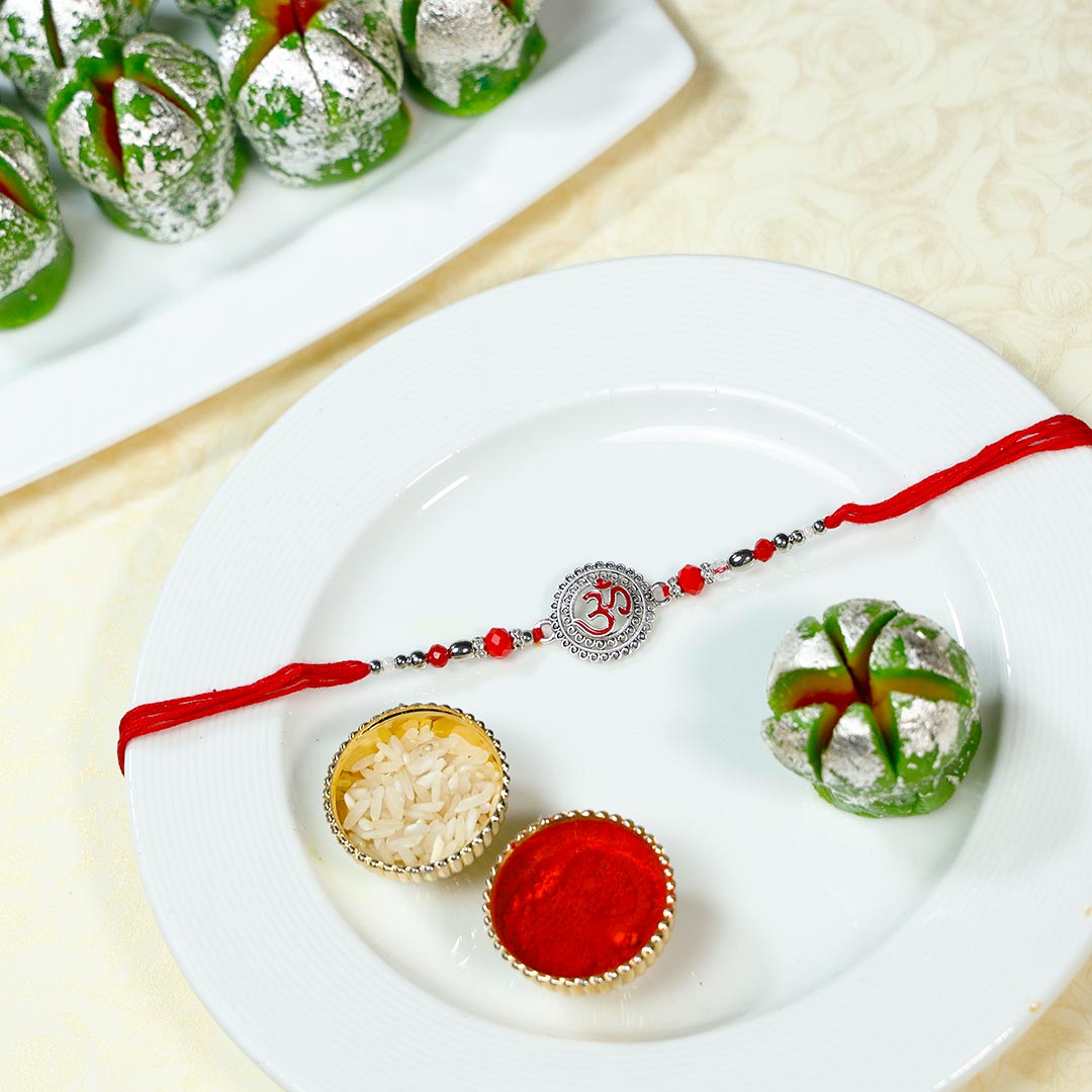 Send OM Centerpiece Rakhi With Kaju Phool Sweets Online